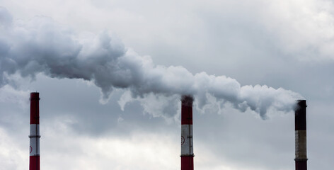 Air pollution from smoke coming from three factory chimneys.