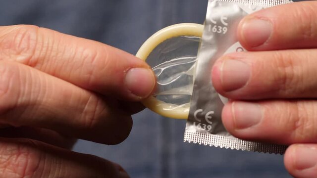Male Hands Taking a Condom, Macro