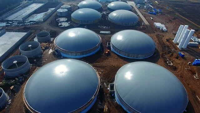 Construction zone of bio fuel plant. Bio gaz factory building in a field.