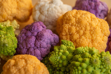 Cauliflower, yellow cauliflower, purple cauliflower and Roman cauliflower placed next to each other.