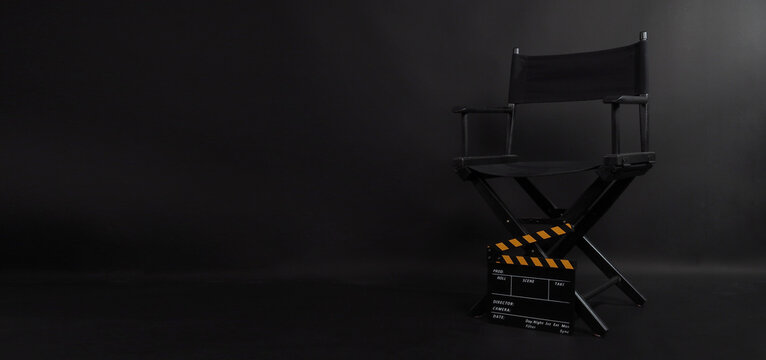 Director chair and Clapper board or movie slate use in video production , film ,movie and cinema industry. It's put on black blackground.