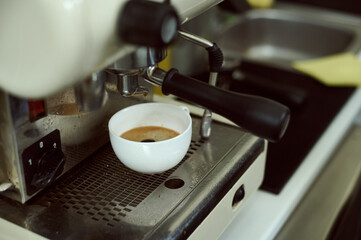 White espresso cup on a professional coffee machine