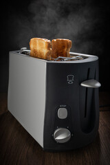 Toaster with ready-made fresh toast on deep dark background