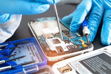 Technician repairing inside of mobile phone by soldering iron. Integrated Circuit. the concept of data, hardware, technology.