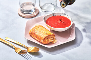 Ham and Cheese Croissant with Olive Oil Pouring into Tomato Soup