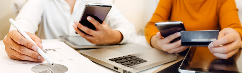 Businesswomen hands working with finances about cost and calculator and laptop with tablet, smartphone at office in morning light
