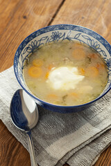 Pickle soup in a blue plate with a white pattern on a napkin