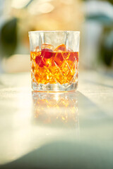 Cocktail Glass with Whiskey or Brown Liquor on Bright Table