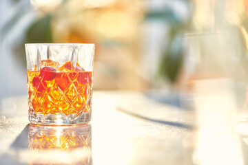 Cocktail Glass with Whiskey or Brown Liquor on Bright Table