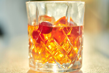 Cocktail Glass with Whiskey or Brown Liquor on Bright Table