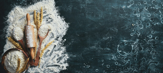 Flour, eggs, and rolling pin, Preparation of dough. Bakery on a black stone background. Top view....