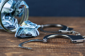 crumpled dollars and open handcuffs
