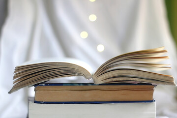 Stack of used books. Selective focus, bokeh lights.