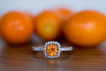 orange kumquats behind orange stone ring