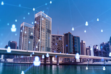 Fototapeta premium Skyscrapers of Dubai business downtown. International hub of trading and financial services. Social network icons hologram, concept of people connection. Double exposure. Dubai Canal waterfront.