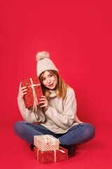 Dreaming winter girl sitting holding christmas present 