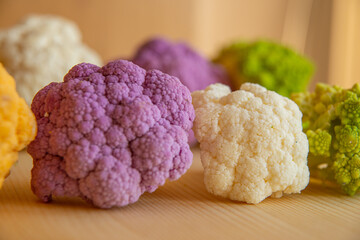 Cauliflower, yellow cauliflower, purple cauliflower and Roman cauliflower placed next to each other.