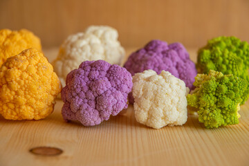 Cauliflower, yellow cauliflower, purple cauliflower and Roman cauliflower placed next to each other.