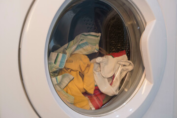 colorful clothes in the washing machine, preparing for washing.