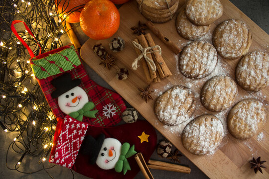 Christmas stocking, cinnamon sticks, tangerines and cookies on dark gray background with copy space. Festive decorations top view photo. 
