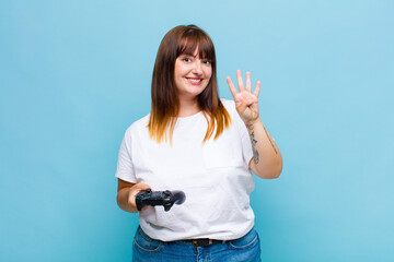 plus size woman smiling and looking friendly, showing number four or fourth with hand forward,...