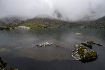 high mountain lake Akkem with mountains shrouded in clouds