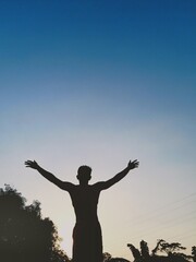 silhouette of a person with arms raised