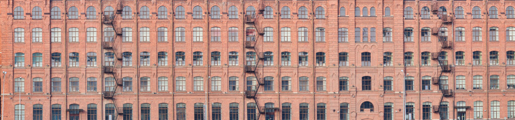 Fototapeta na wymiar steel staircases and windows on old orange brick wall