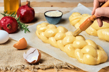 Easter baked goods, challah or zopf buns. Proof before placing in the oven. Brush on butter buns before baking. Close-up. Braided sweet bread dough.