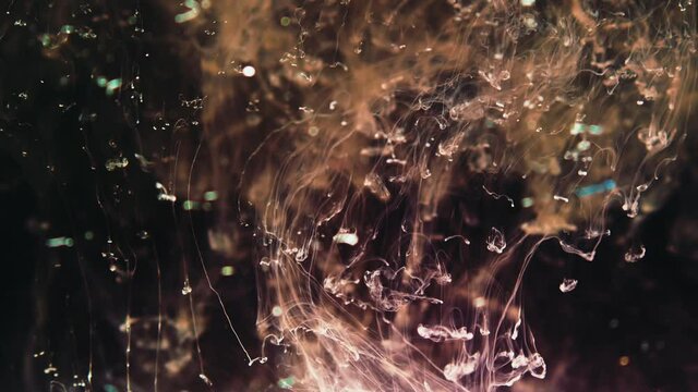 Ink dramatically descends through liquid on black background, abstract