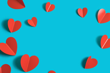 Festive background with red paper hearts on a bright blue background for Valentine's Day. Flatlay. Top view. Copyspace.