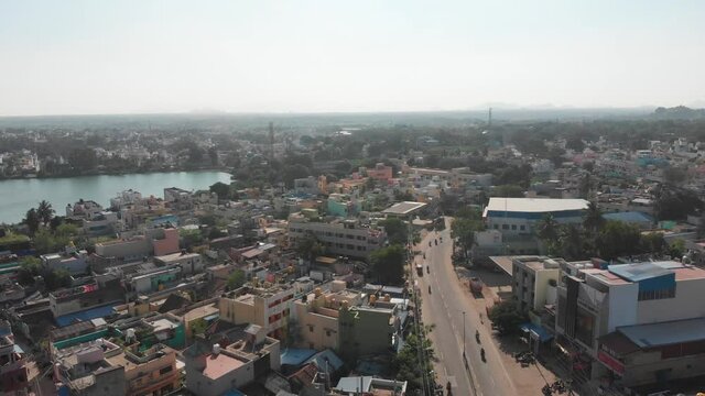 Aerial flight along main road in Tiruvannamalai City and natural pond in the middle of town.Beautiful sunny day