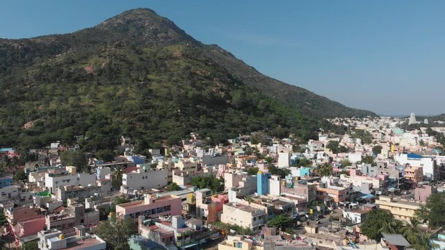 Beautiful aerial shot of housing area bordering huge mountain in India.Cinematic drone footage.
