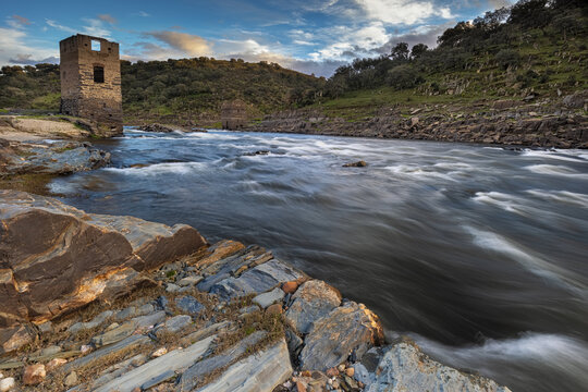 Landscape with ancient towers on the bank of the Alagon river. Spain.