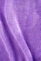 knitting background in lilac color with space for text. knitted sweater.handmade work.the concept of knitting.