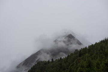 Altai mountains shrouded in white clouds, it looks quite gloomy