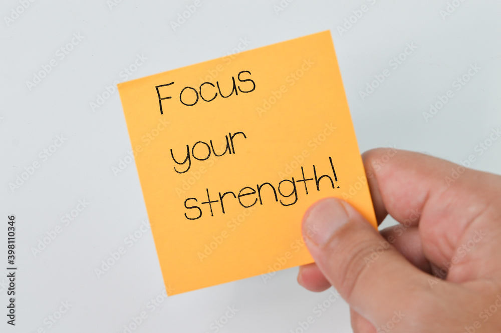 Wall mural man hand holding memo note written with text focus your strength!. business and education concept.