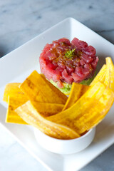 Tuna tartare. Classic American restaurant or bistro appetizer classic. Sushi grade ahi tuna, diced, mixed with eggs, red onions, olive oil, lemon juice, garlic and capers. Served with garlic bread.