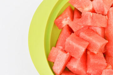 Close up view of watermelons on a green plate.  Tropical fruits on a white background. 