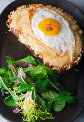 Croque madame or monsieur. Breakfast or brunch favorite: toast, with fried eggs, ham, cheese and hollandaise sauce. Served with potato hash. Classic French bistro or American restaurant entree.