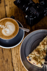 Cup of hot Cappuccino coffee on wooden table at cafe. with Cake Fresh invigorating drink with camera
