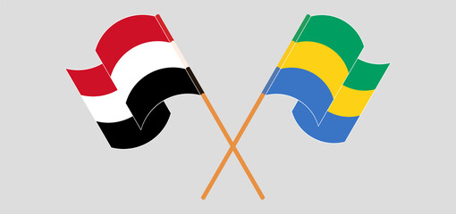 Crossed and waving flags of Yemen and Gabon