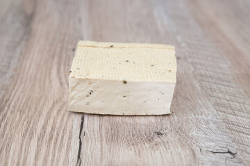 piece of tofu cheese over wood background.