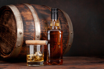 Scotch whiskey bottle, glass, cigar and old barrel