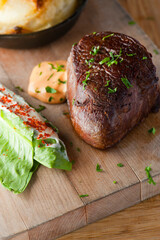 Steak and potatoes. Grade A grass fed angus beef steaks. Tenderloin, filet mignon, New York strip, bone in rib-eye grilled medium rare on outdoor wood-fired grill. Classic American steakhouse entree.