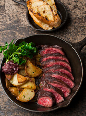 Steak and potatoes. Grade A grass fed angus beef steaks. Tenderloin, filet mignon, New York strip, bone in rib-eye grilled medium rare on outdoor wood-fired grill. Classic American steakhouse entree.