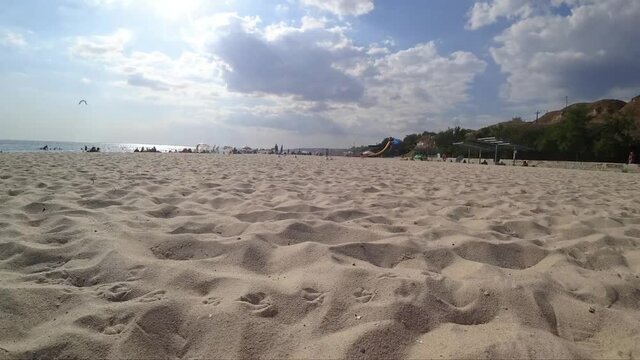 Beach with tourists next to the sea, summer. Sand and sky. Time lapse. Ochakov (Ochakiv), Black Sea. Ukraine.