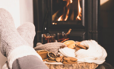 mulled wine by the fireplace, 2 glasses of drink, spices, a warm scarf and feet in warm socks near the stove