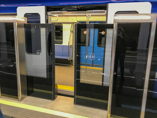 A modern high-speed train in a new beautiful modern underground station and protective glass sliding doors to the car
