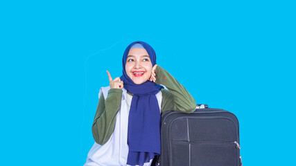 Portrait of a cheerful young asian  woman wearing hijab - traveling concept